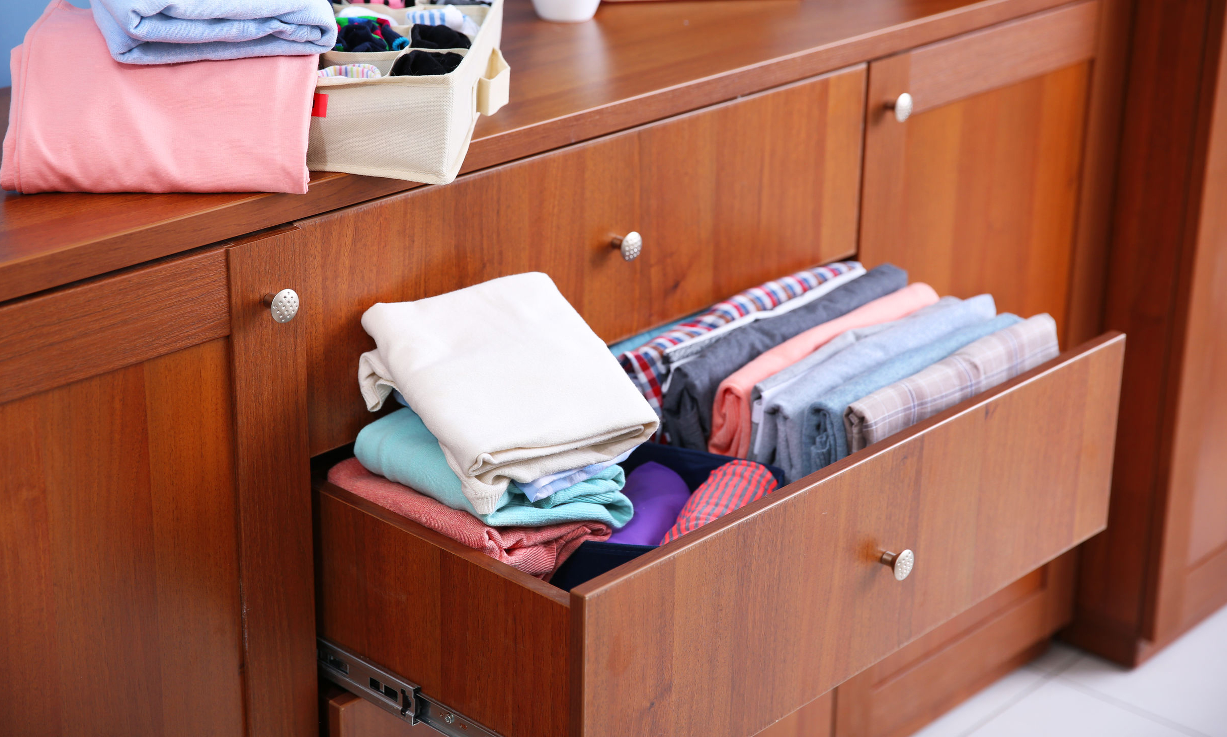 Neatly folded clothes in wooden drawer